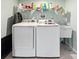 Well-lit laundry room features a utility sink, washer, dryer and ample storage space with overhead shelving at 749 Scarlet Ne Dr, Kennesaw, GA 30144