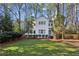 Charming white two-story house with well-manicured lawn and mature trees at 2460 Oldfield Rd, Atlanta, GA 30327