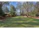 Large grassy yard with mature trees and a view of the house at 2460 Oldfield Rd, Atlanta, GA 30327