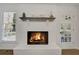 Close up of a painted fireplace with a black mantle, flanked by a window and an exterior door at 2622 Marcia Dr, Lawrenceville, GA 30044