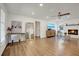 Bright living room featuring a painted brick fireplace, wood floors, a ceiling fan, and a home office area at 2622 Marcia Dr, Lawrenceville, GA 30044