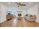 Cozy living room featuring a fireplace, wood floors, a ceiling fan, and plenty of natural light at 2622 Marcia Dr, Lawrenceville, GA 30044