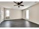 Spacious bedroom with dark gray flooring, ceiling fan, and two windows at 5815 Feldwood Rd, Atlanta, GA 30349