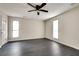 Spacious bedroom with dark gray flooring, ceiling fan, and two windows at 5815 Feldwood Rd, Atlanta, GA 30349