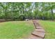 Spacious backyard with steps and wooden dog house at 212 Teepee Trl, Whitesburg, GA 30185