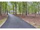 View of the long asphalt driveway leading up to the house through the trees at 212 Teepee Trl, Whitesburg, GA 30185