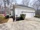 Exterior showcasing attached garage, garden, and bushes surrounding the house at 212 Teepee Trl, Whitesburg, GA 30185