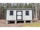 New outbuilding with white siding and a dark door, situated on concrete blocks at 212 Teepee Trl, Whitesburg, GA 30185