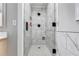Elegant shower featuring large-format marble-style tiling, sleek black hardware, and a niche for storage at 212 Teepee Trl, Whitesburg, GA 30185