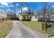 Street view of cozy home with painted brick, quaint porch, long driveway, and fenced yard at 2409 Swallow Se Cir, Atlanta, GA 30315