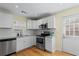 Bright kitchen featuring stainless steel appliances, white cabinetry, and refinished hardwood floors at 2409 Swallow Se Cir, Atlanta, GA 30315