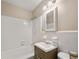 A well-lit bathroom featuring a tub, white tile, and simple vanity at 6550 Bridgewood Valley Rd, Atlanta, GA 30328