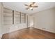 Bedroom featuring hardwood floors and a built-in bookcase, with a ceiling fan at 6550 Bridgewood Valley Rd, Atlanta, GA 30328