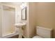 Bathroom featuring a pedestal sink, toilet, and walk-in shower with white tile surround at 1901 Shelburne Cv, Marietta, GA 30068