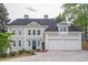 Elegant two-story home with a neutral-toned stucco exterior and a spacious three-car garage and well manicured lawn at 1901 Shelburne Cv, Marietta, GA 30068