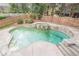 An in-ground pool features a waterfall, surrounding stone, and wooden fencing at 1901 Shelburne Cv, Marietta, GA 30068
