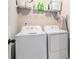 Functional laundry room equipped with a washer, dryer, and overhead shelving at 366 Cherryhill Ln, Woodstock, GA 30188