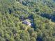 Aerial view showcasing a house with backyard and detached building amongst trees at 946 Gaithers Rd, Mansfield, GA 30055