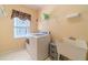 Convenient laundry room includes washer, dryer, shelving, and utility sink at 946 Gaithers Rd, Mansfield, GA 30055
