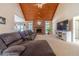 Bright living room with a stone fireplace, vaulted wood ceiling and large sectional sofa at 946 Gaithers Rd, Mansfield, GA 30055
