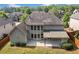 Back exterior view of home with a covered patio, lush green lawn, and ample space at 231 Haney Rd, Woodstock, GA 30188