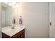 Simple half bathroom with a dark wood vanity and a large mirror at 231 Haney Rd, Woodstock, GA 30188