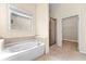 Bathroom featuring a soaking tub, walk-in shower, and tile flooring at 231 Haney Rd, Woodstock, GA 30188