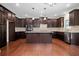 Gourmet kitchen with dark wood cabinets, large island, and stainless steel appliances at 231 Haney Rd, Woodstock, GA 30188