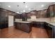 Spacious kitchen with dark cabinets, granite countertops, stainless steel appliances, and hardwood floors at 231 Haney Rd, Woodstock, GA 30188