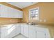 Simple kitchen with white cabinets, laminate countertops, and a window overlooking the yard at 337 N Clayton St, Lawrenceville, GA 30046