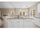 Kitchen island with granite countertop and white cabinets at 780 Treadstone Ct, Suwanee, GA 30024