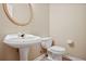 Powder room with pedestal sink and gold framed mirror at 780 Treadstone Ct, Suwanee, GA 30024