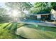 Putting green and pool in a sunny backyard, perfect for outdoor fun at 5190 Crestview Dr Se, Covington, GA 30014