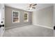 Well-lit bedroom featuring two windows, ceiling fan, and plush carpeting at 115 Parkside Close, Alpharetta, GA 30022