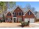 Two-story brick home with a two-car garage and mature trees at 115 Parkside Close, Alpharetta, GA 30022