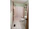 Bathroom featuring a shower with pink curtain, white tiled floor, and a white cabinet at 309 Juanita Ln, Powder Springs, GA 30127