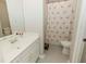 Bathroom with flamingo shower curtain, white cabinets and hexagon tile floor at 9919 Bridgewater Pointe, Villa Rica, GA 30180