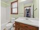 Clean bathroom with wood vanity, a tub, and a toilet at 215 Silver Creek Ln, Stockbridge, GA 30281