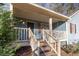 Inviting front porch with wooden swing and string lights at 215 Silver Creek Ln, Stockbridge, GA 30281