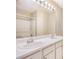 Bright bathroom with dual sinks, white cabinets, large mirror with vanity lighting, and bathtub with shower at 3712 Berkeley Xing, Duluth, GA 30096