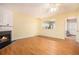 Bright living room with wood floors, fireplace, and view into the kitchen with white cabinets and stainless steel appliances at 3712 Berkeley Xing, Duluth, GA 30096