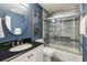 Stylish bathroom featuring a vanity, round mirror, and glass-enclosed shower over tub at 64 Devon Ln, Avondale Estates, GA 30002
