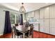 Dining area featuring hardwood floors, contemporary lighting, built in cabinets, and a large window at 64 Devon Ln, Avondale Estates, GA 30002