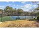 Fenced tennis court in a community setting with greenery and trees surrounding it at 64 Devon Ln, Avondale Estates, GA 30002