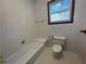 Clean bathroom with a bathtub, toilet, and tiled floors at 10995 Parsons Rd, Johns Creek, GA 30097