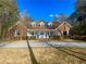 Brick home with a spacious front yard and long driveway at 10995 Parsons Rd, Johns Creek, GA 30097
