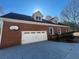 Brick home with a white garage door and basketball hoop at 10995 Parsons Rd, Johns Creek, GA 30097