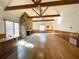 Gathering room with stone fireplace, wood beams, and hardwood floors at 10995 Parsons Rd, Johns Creek, GA 30097