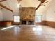 Gathering room with a stone fireplace and hardwood floors at 10995 Parsons Rd, Johns Creek, GA 30097