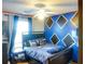 Bedroom with blue and black diamond accent wall and ceiling fan at 3756 Harvest Dr, Atlanta, GA 30034